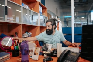 a man with a beard sitting at a desk