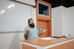 a man with a beard standing in front of a desk