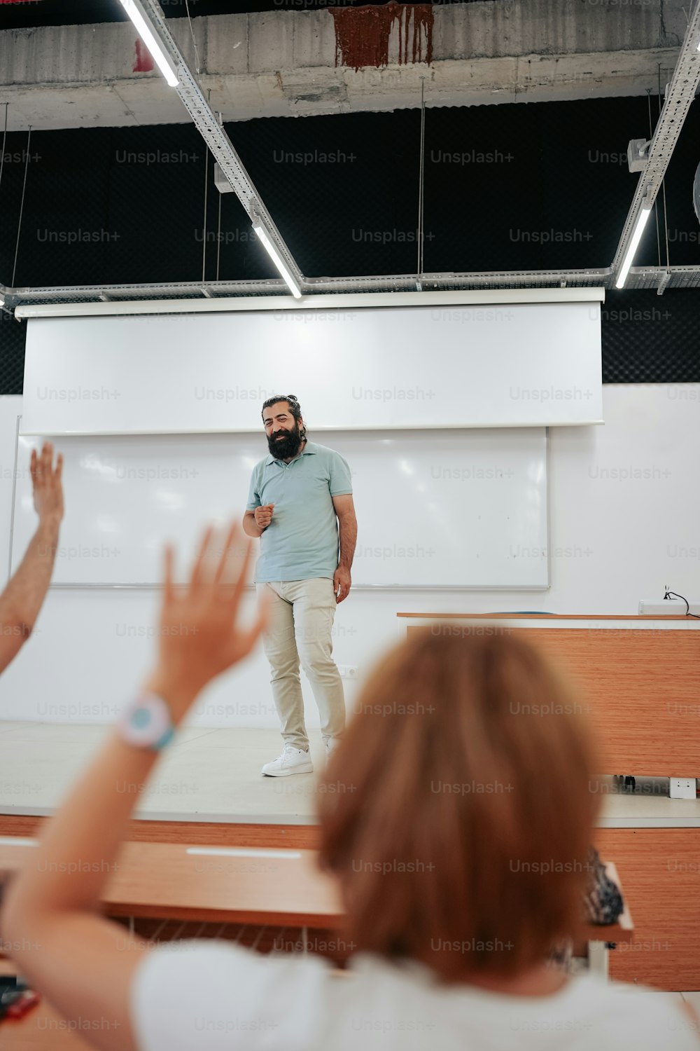 a man standing in front of a whiteboard in a classroom