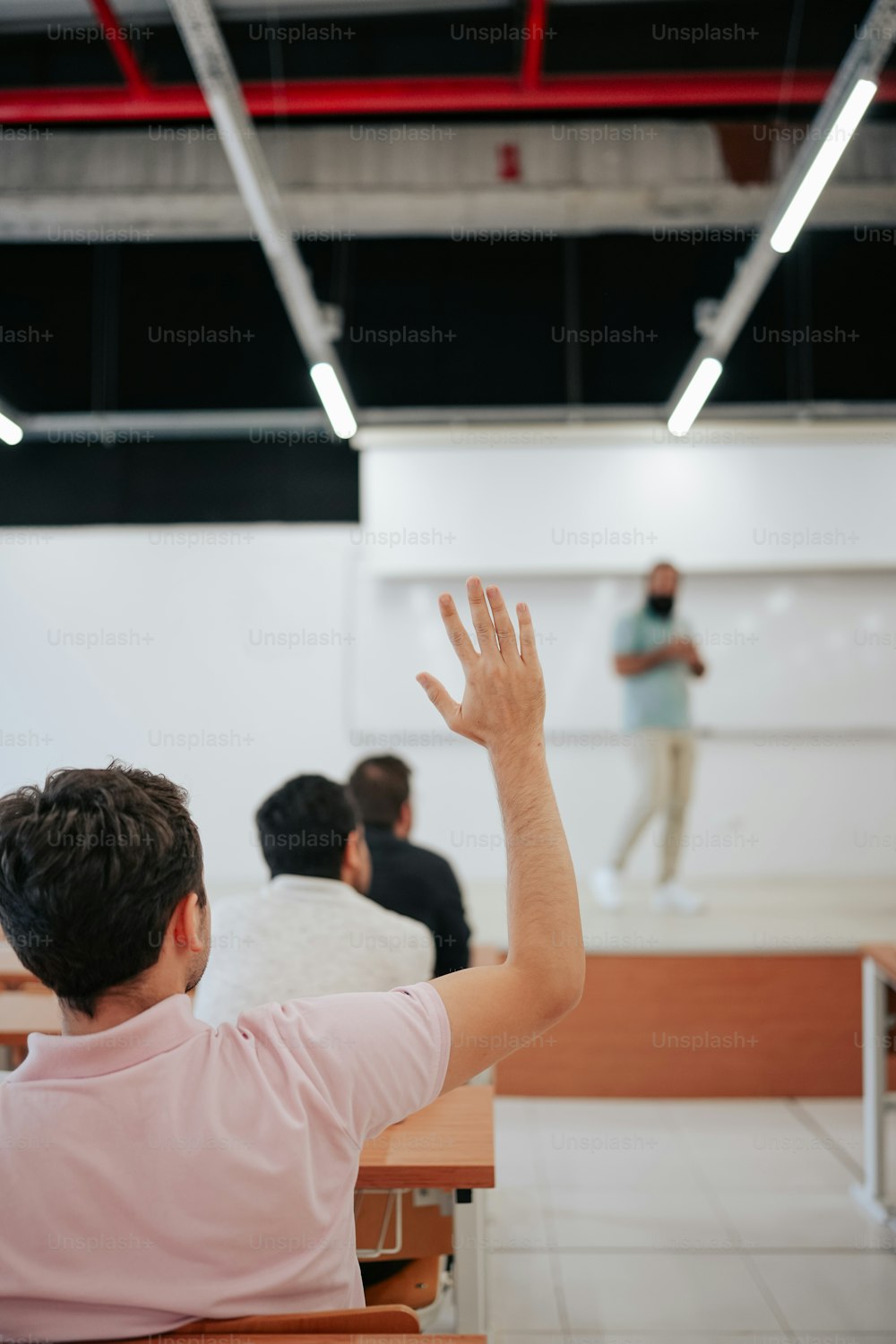 Un hombre parado frente a una pizarra en un aula