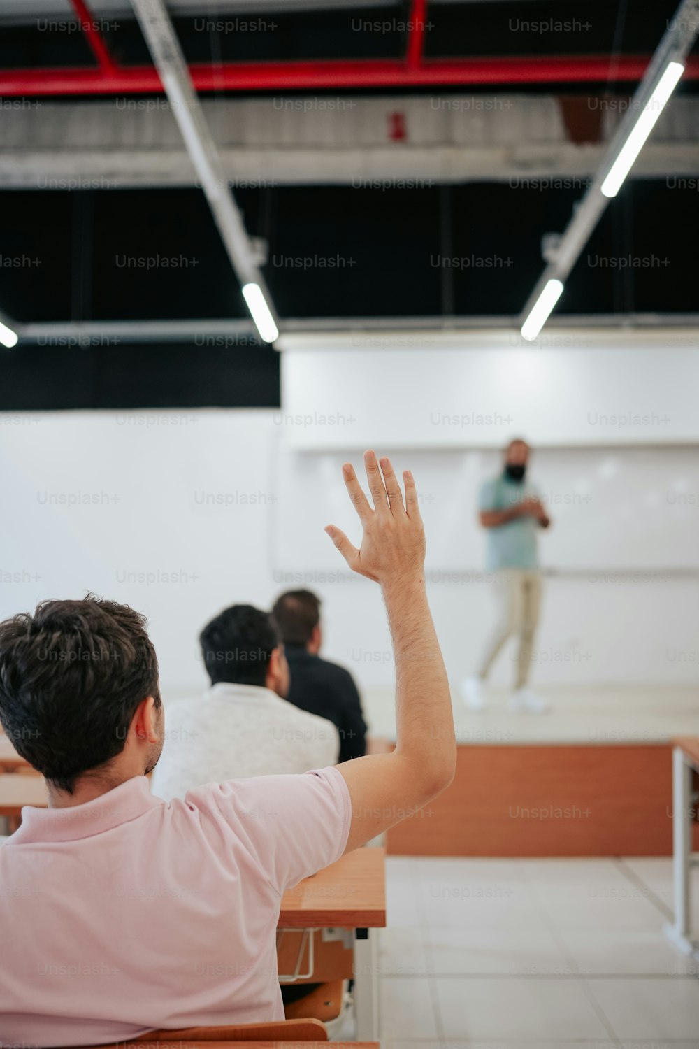 Un homme debout devant un tableau blanc dans une salle de classe