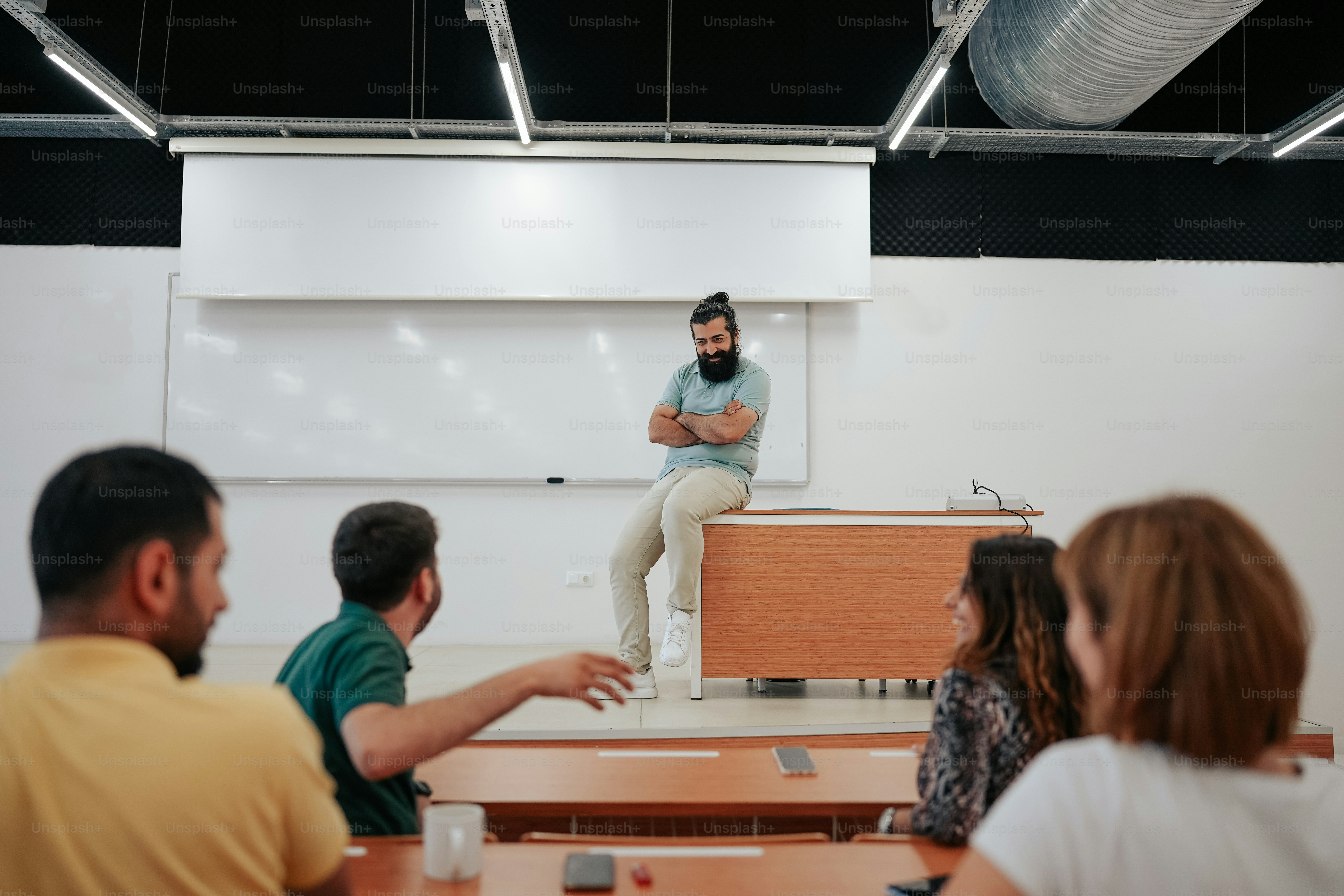 a man standing in front of a class room full of people
