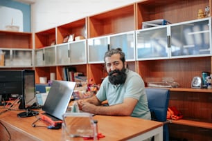 Un hombre sentado en un escritorio con una computadora portátil