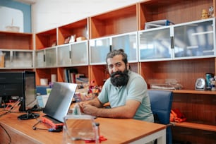 a man sitting at a desk with a laptop