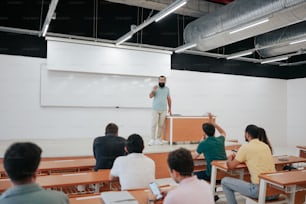 a man standing in front of a class room full of people