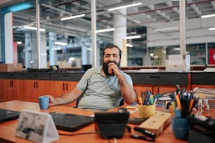 Un hombre con barba sentado en un escritorio