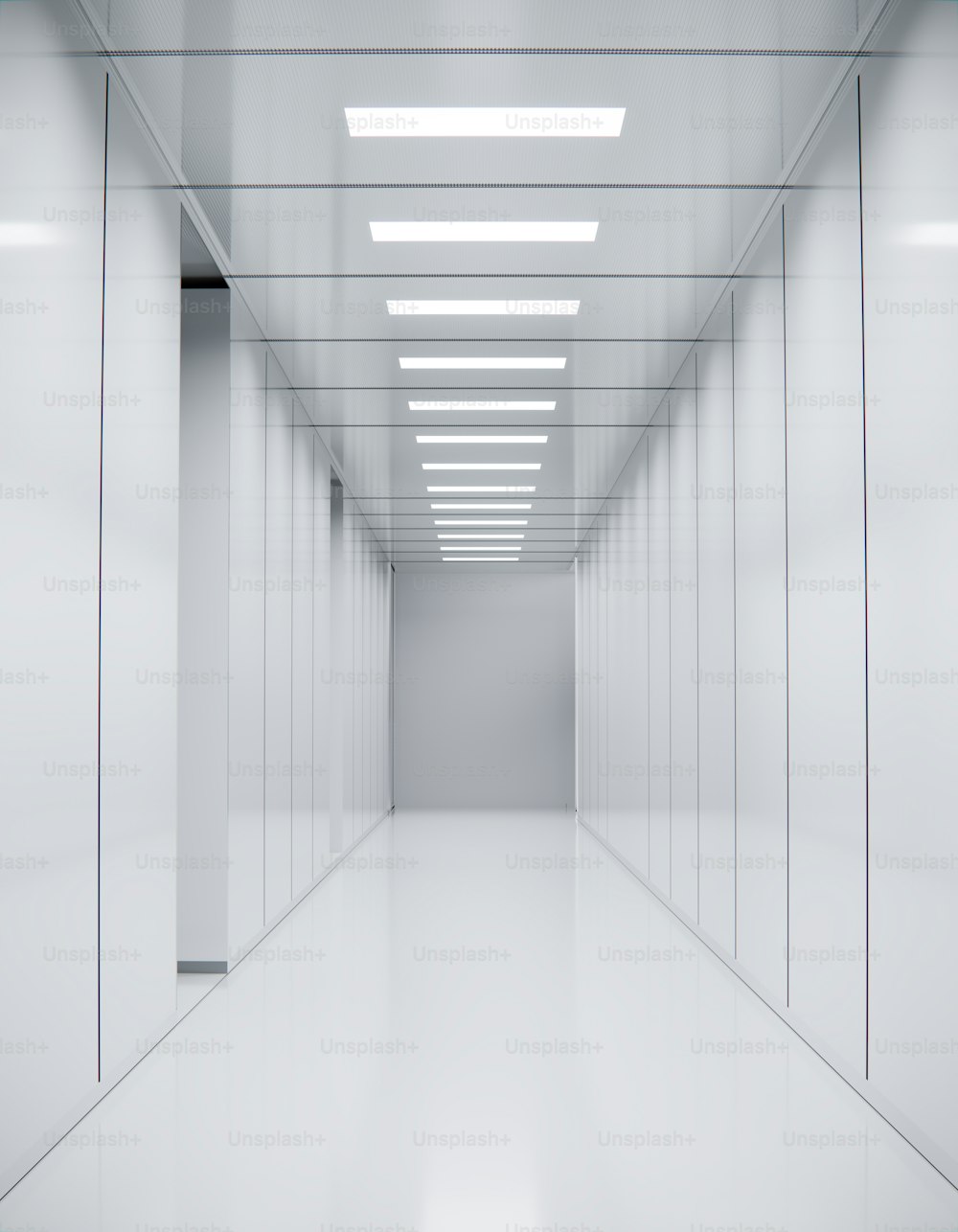 a long hallway with white walls and ceiling lights