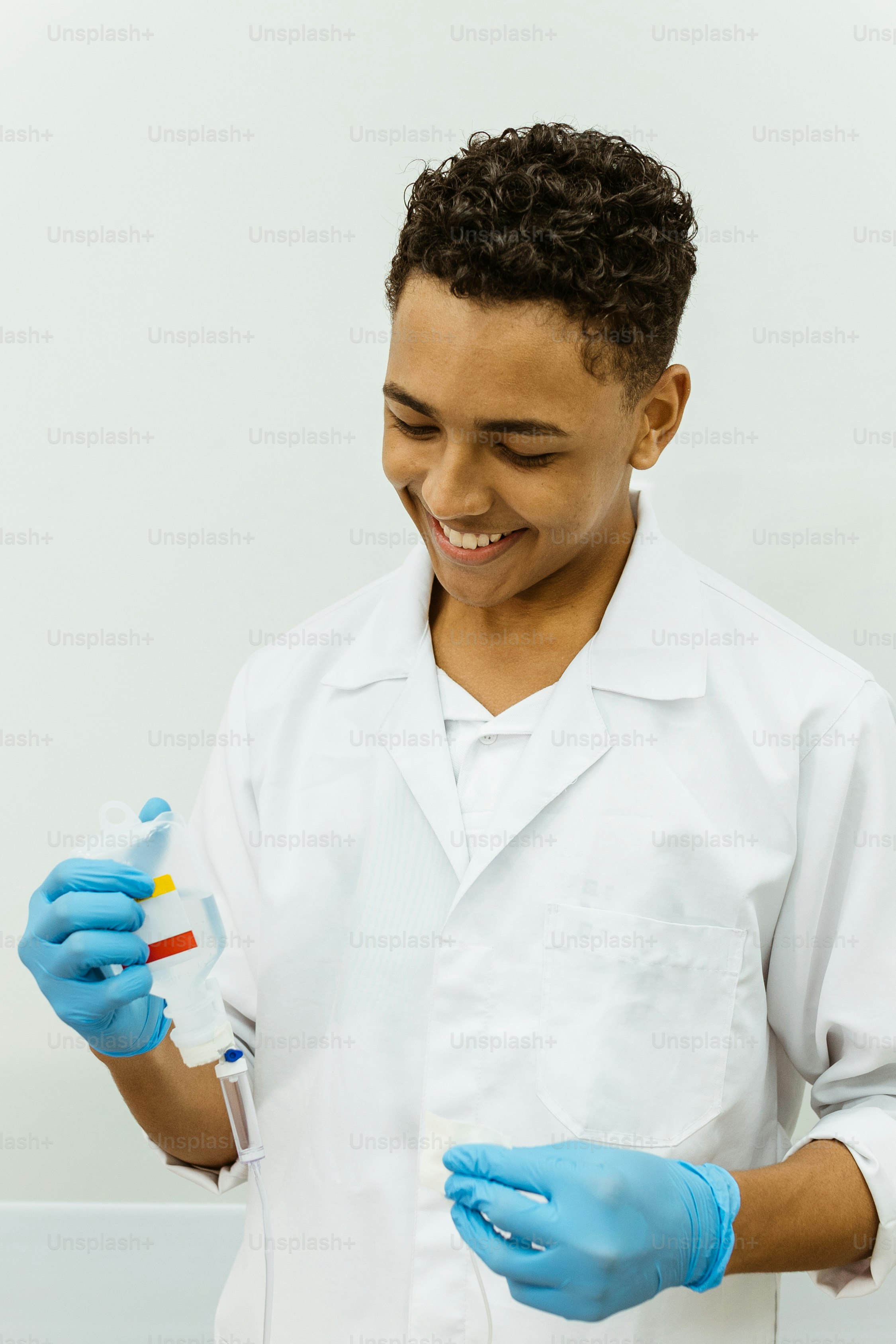 A man in a white lab coat and blue gloves photo – Wellness Image on ...