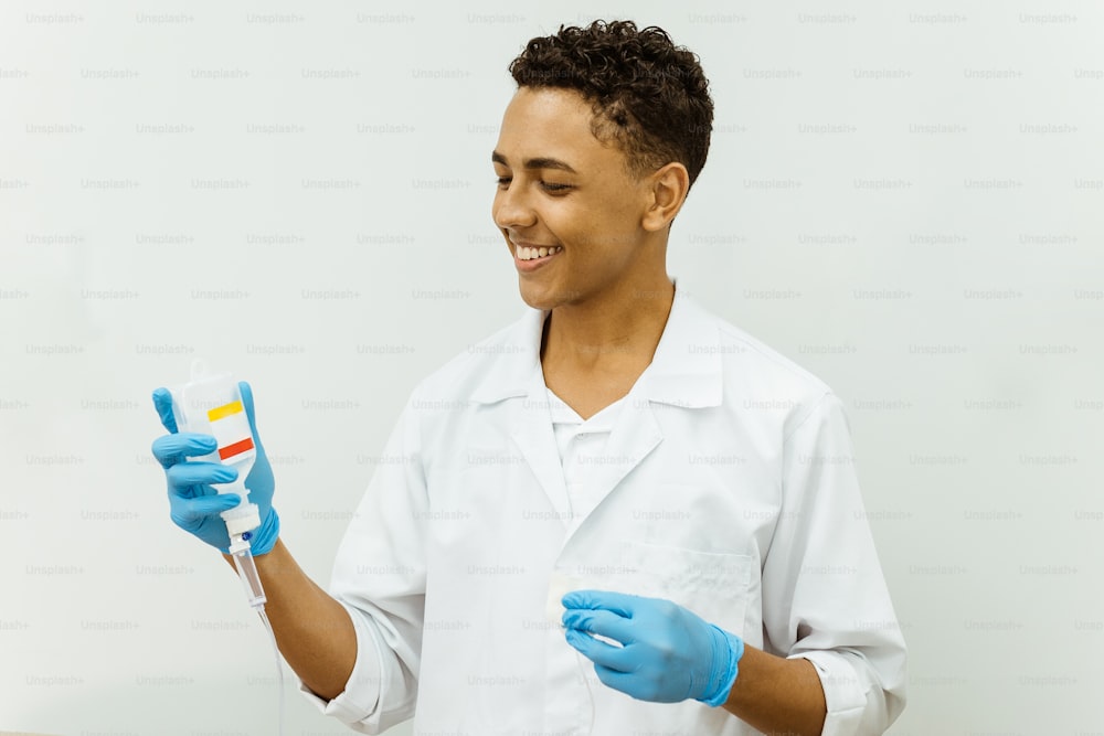 Un homme en blouse de laboratoire et gants tenant une brosse à dents