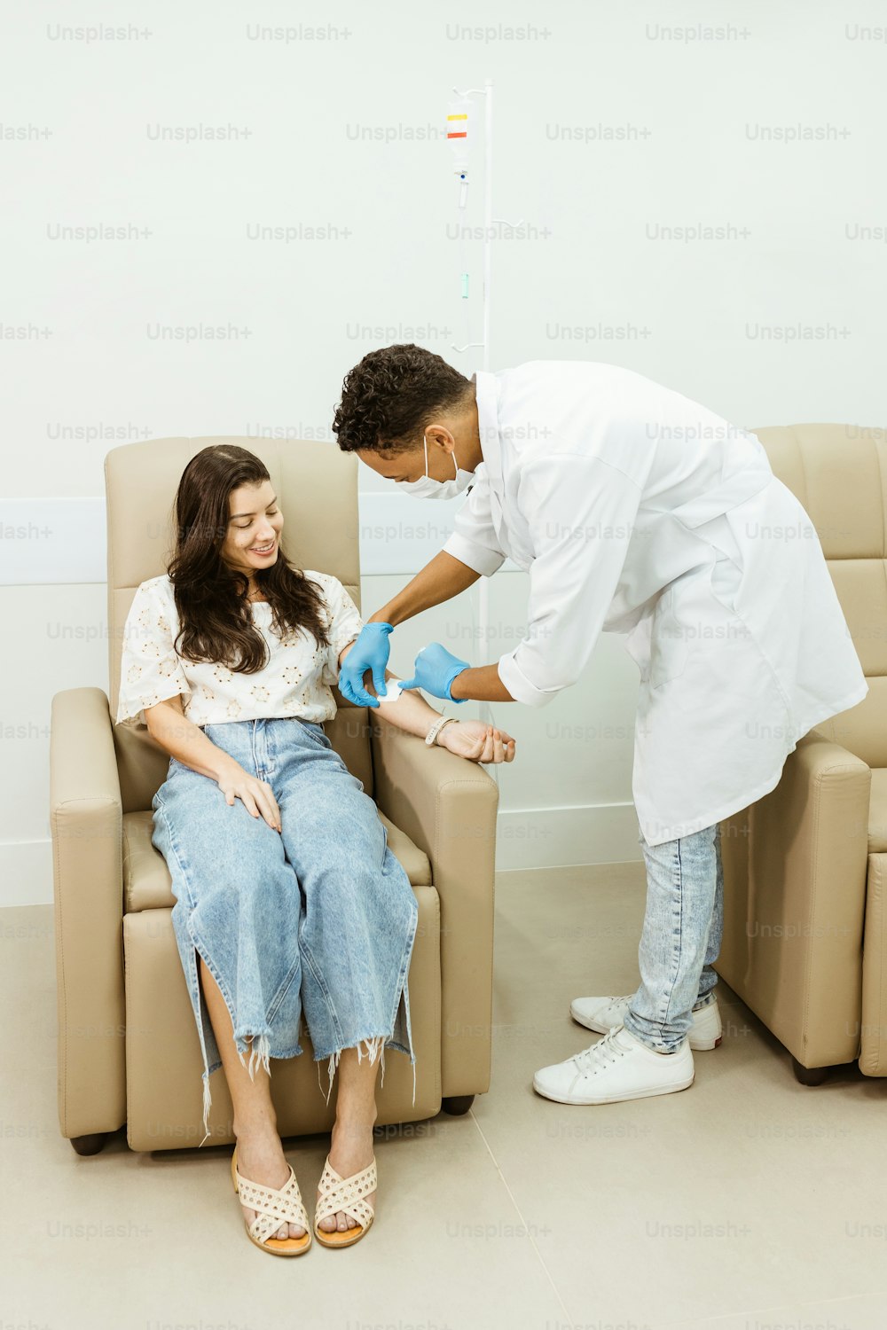 a woman sitting in a chair while a doctor examines her foot