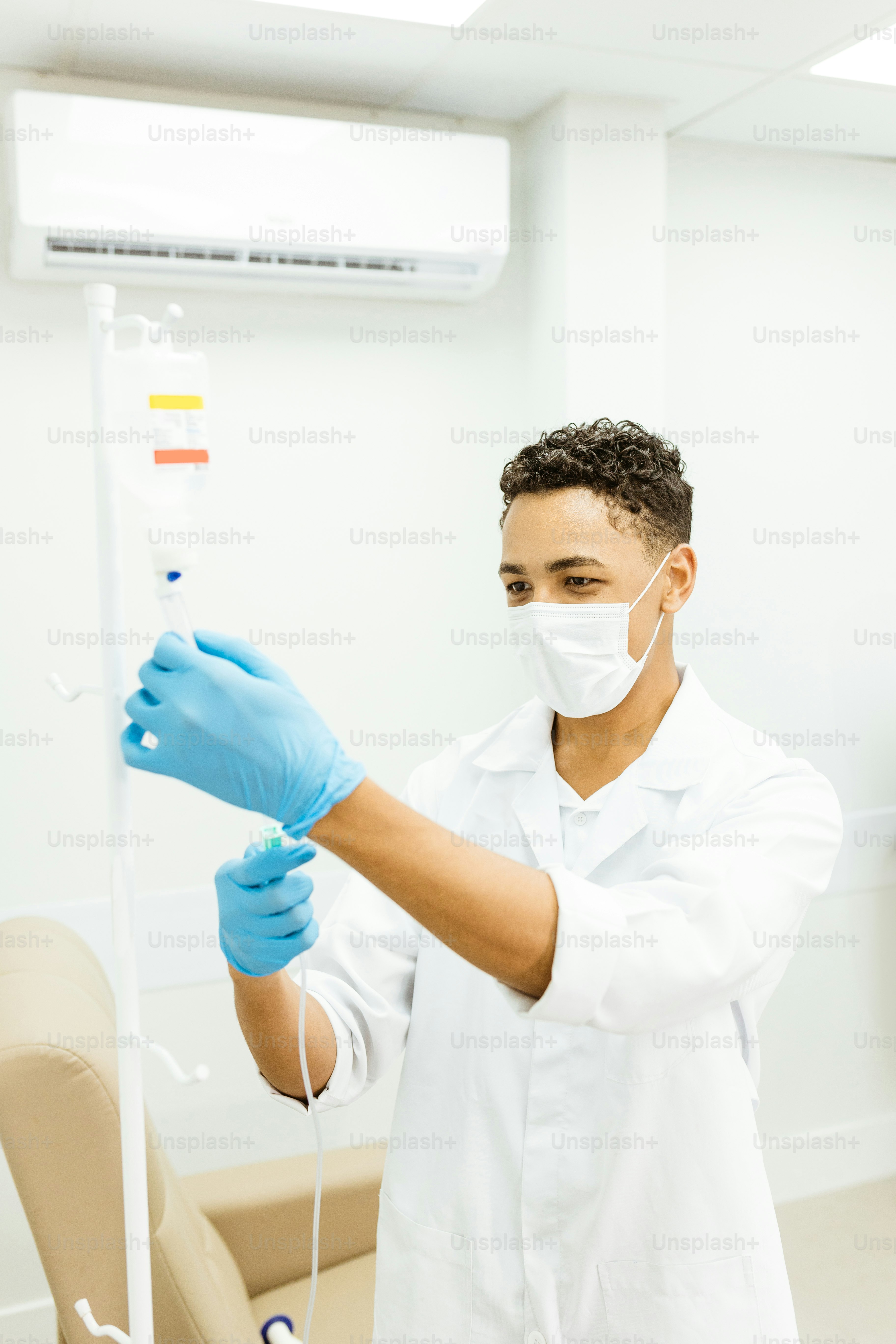 a man in a white lab coat and blue gloves