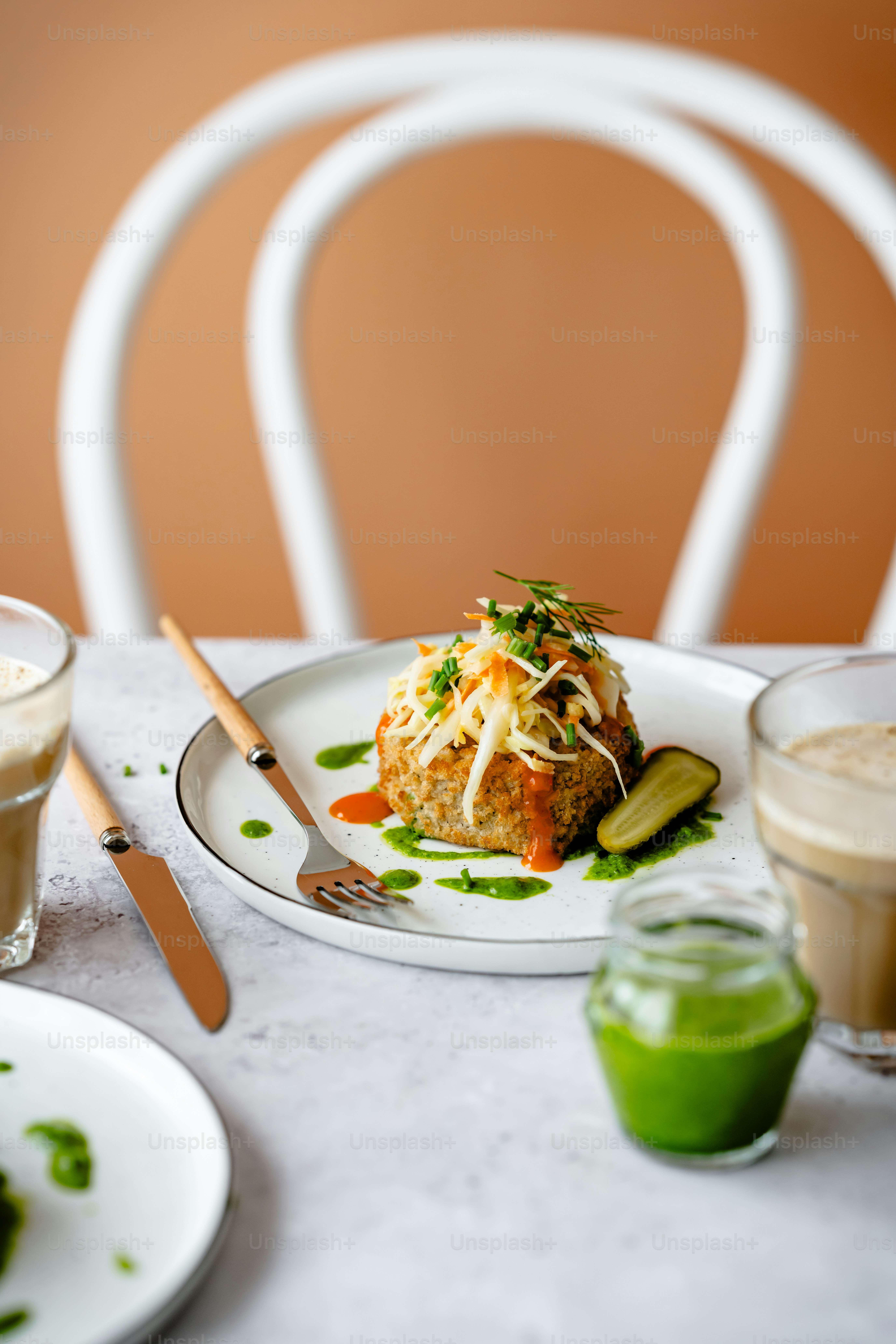 um prato branco coberto com comida ao lado de uma xícara de café