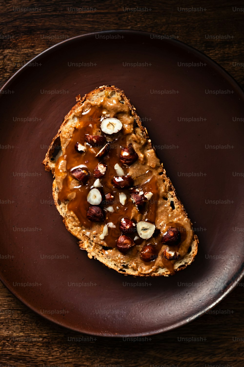 a piece of bread with nuts and cheese on a plate