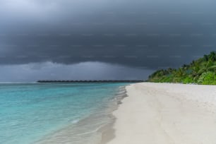 Une plage de sable blanc sous un ciel nuageux
