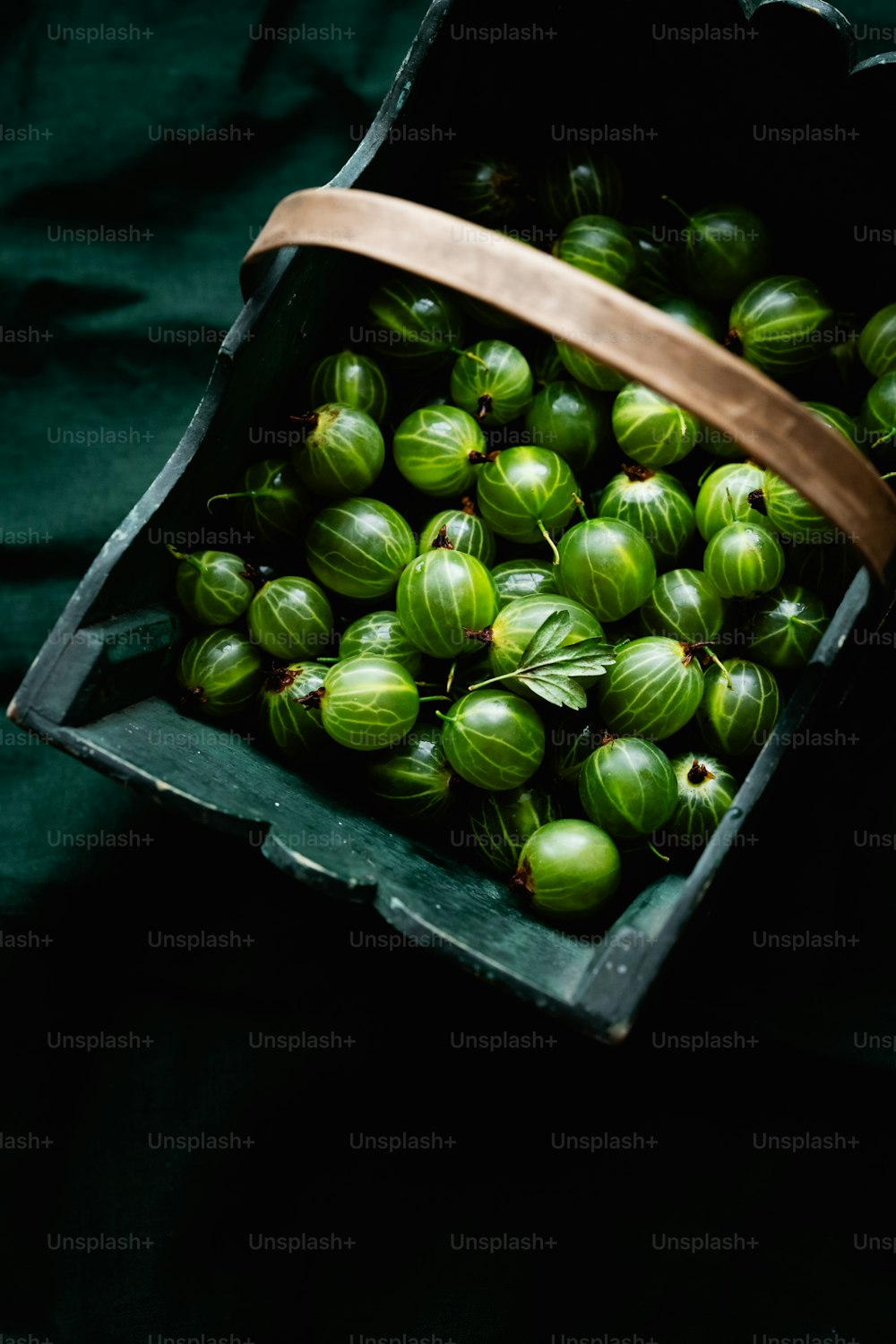 a box filled with green fruit sitting on top of a table