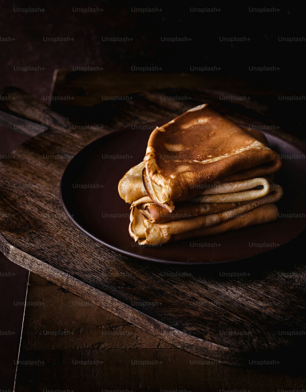 a stack of pancakes sitting on top of a black plate