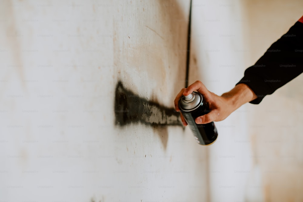 a person spray painting a wall with a spray can