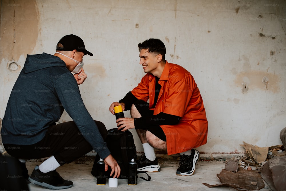 a man in an orange jacket and a man in a black hoodie