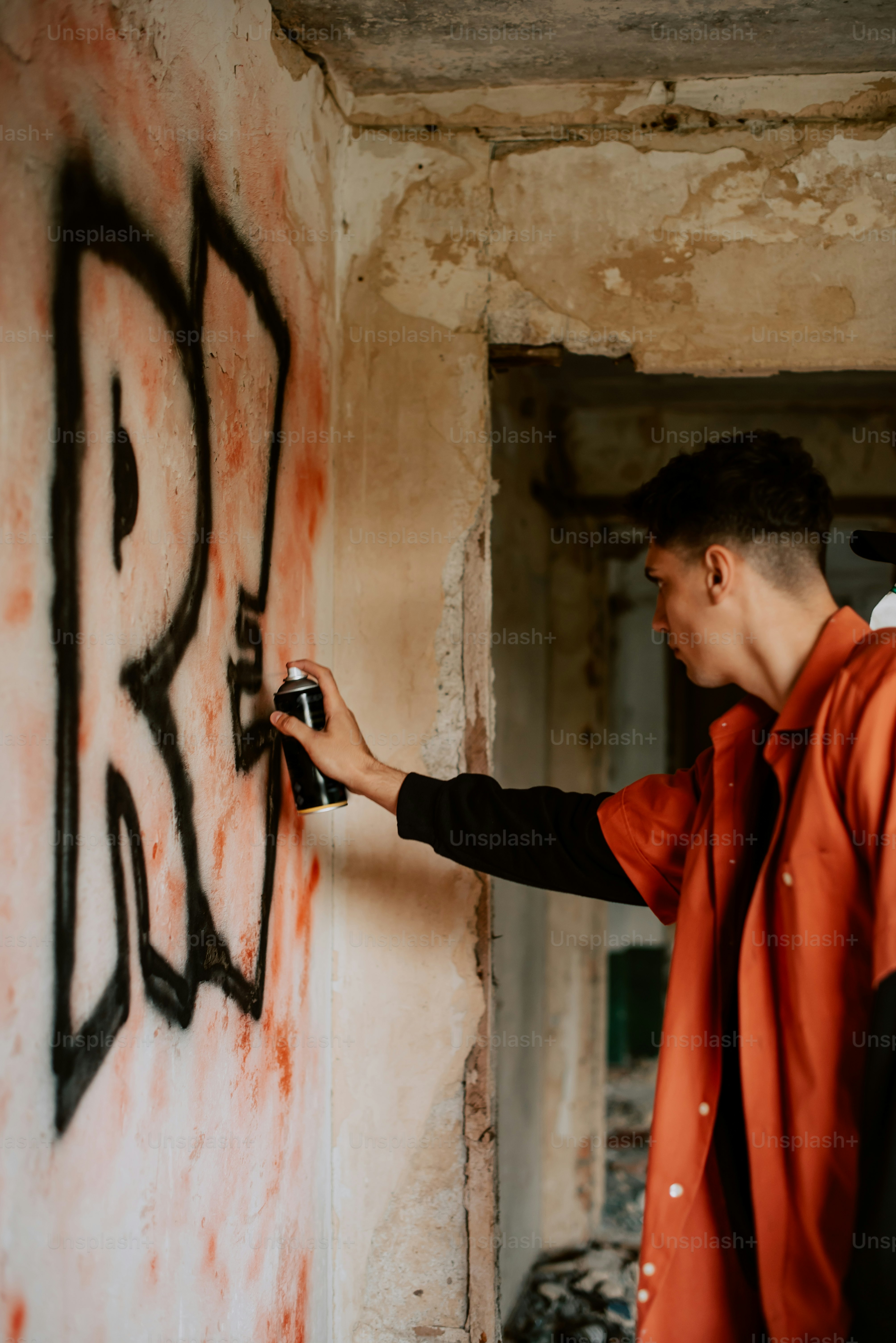 a man spray painting graffiti on a wall