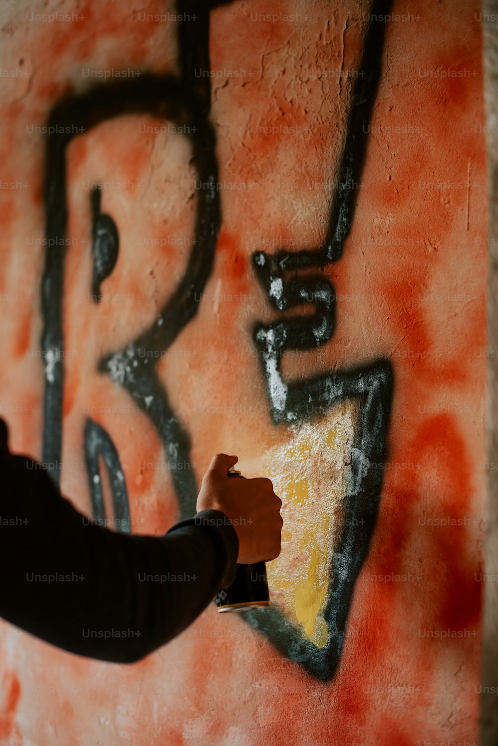 a person is painting a wall with graffiti
