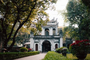 a large white building surrounded by trees and bushes