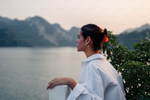 a woman standing next to a body of water