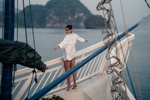 a woman is standing on the deck of a boat