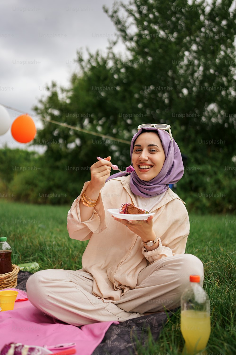 a woman in a hijab eating a piece of cake
