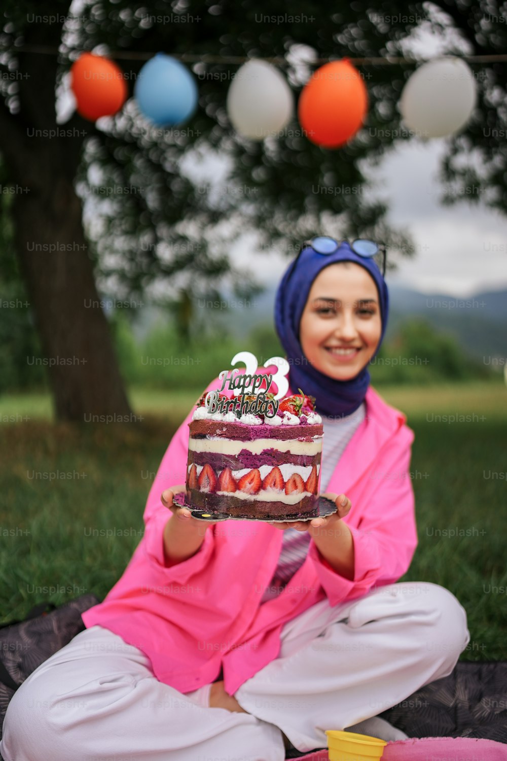 a woman in a hijab holding a birthday cake