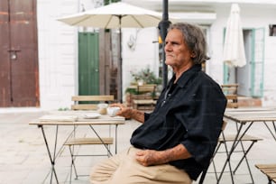 a man sitting at a table with a cup of coffee