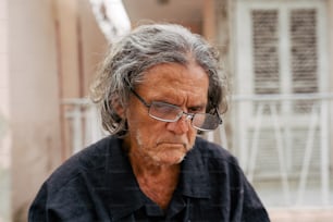 a man with glasses looking at his cell phone