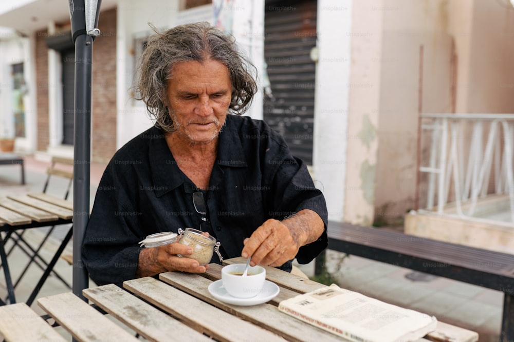 a man sitting at a table with a cup of coffee