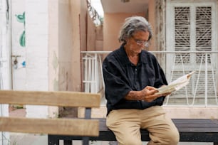 a man sitting on a bench reading a book