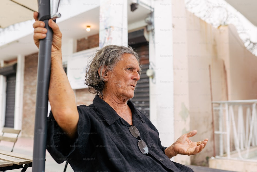 a man sitting in a chair holding a pole
