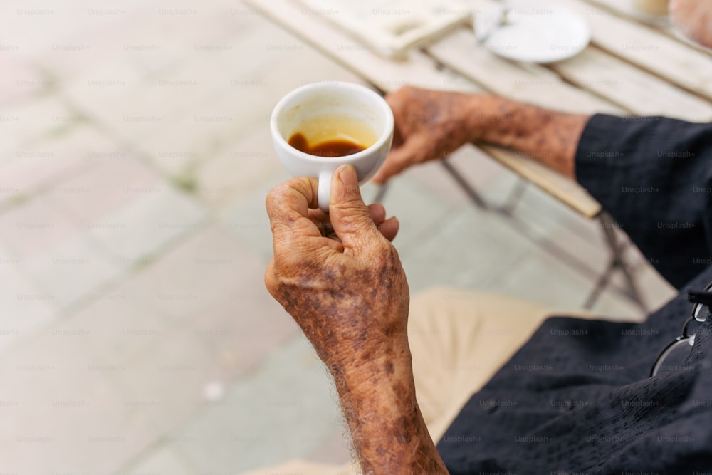 an old man holding a cup of coffee