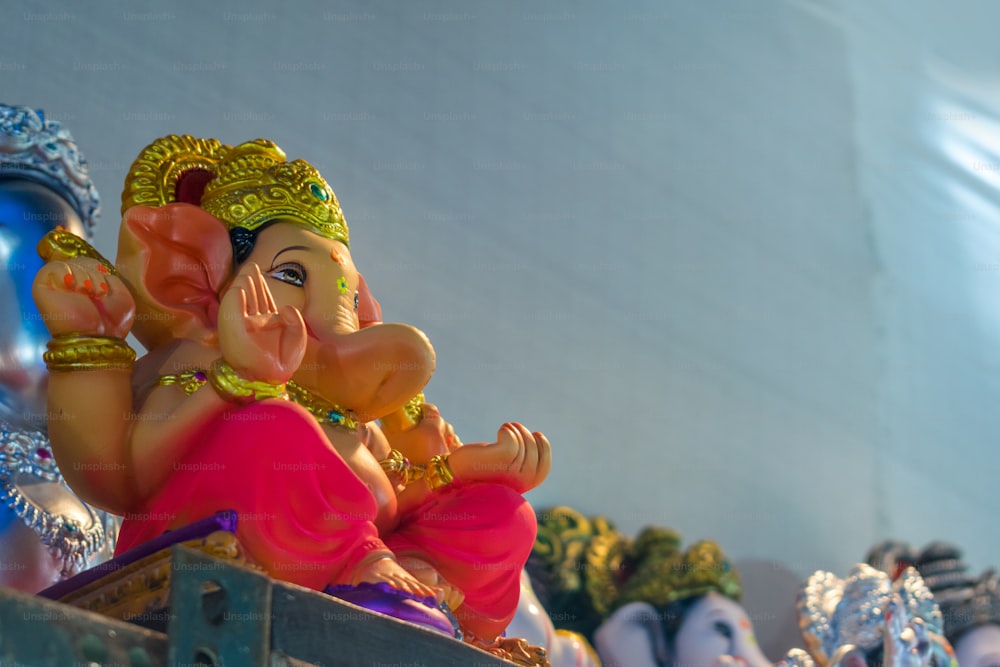 Eine Statue eines Ganeshi, der auf einem Regal sitzt
