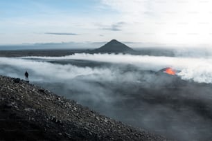 a man standing on top of a mountain surrounded by clouds