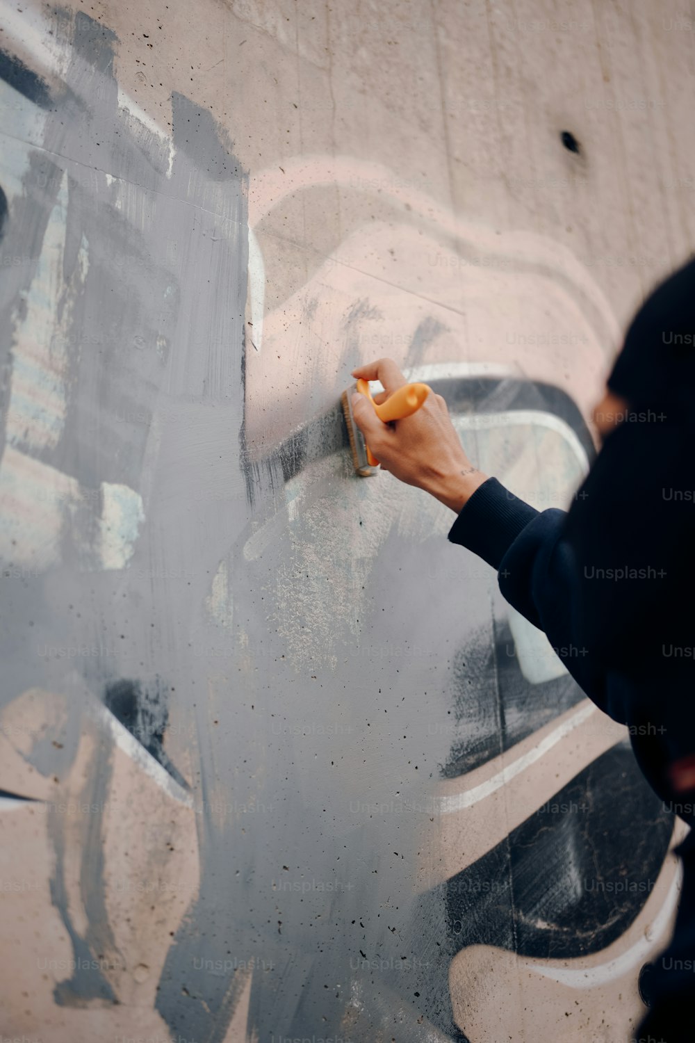 une personne écrivant sur un mur avec un marqueur