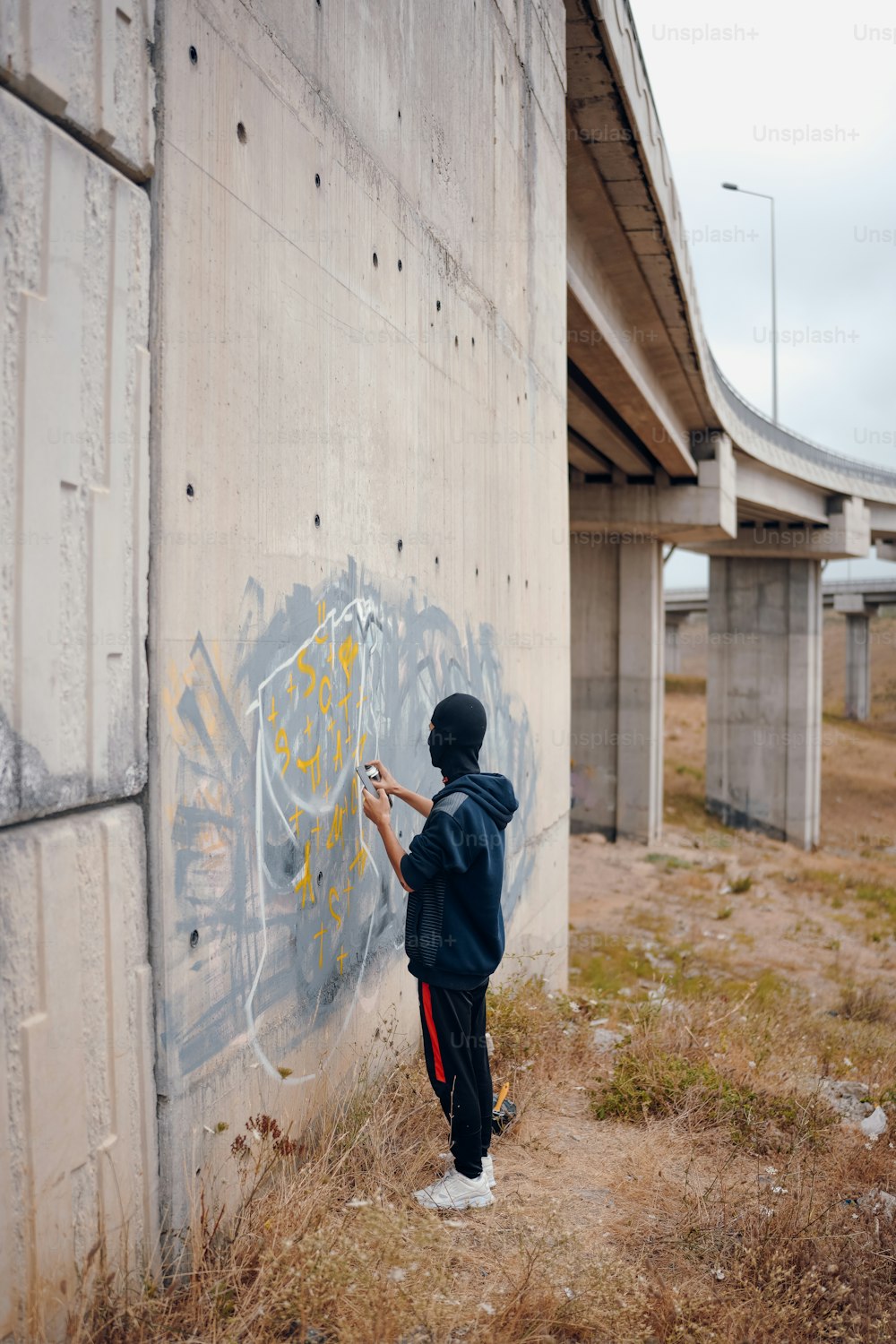 a person writing graffiti on the side of a building