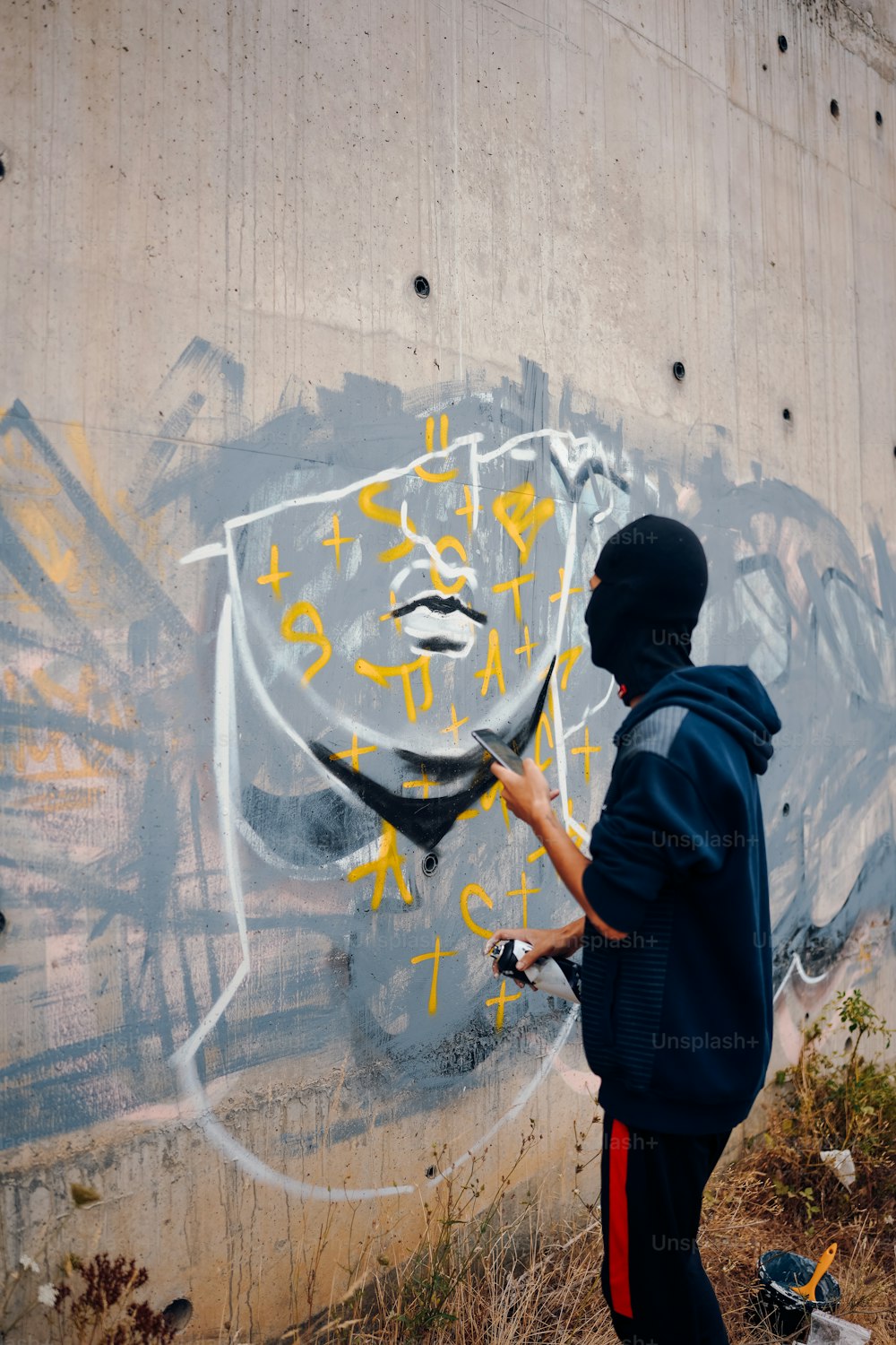um homem pintando grafite na lateral de uma parede