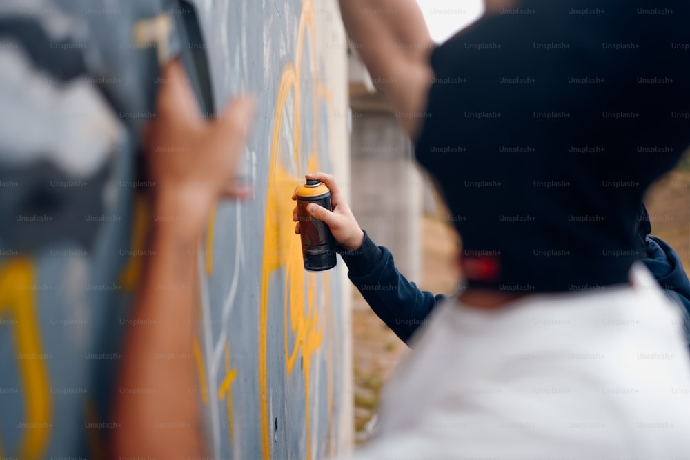 a person painting a wall with yellow paint
