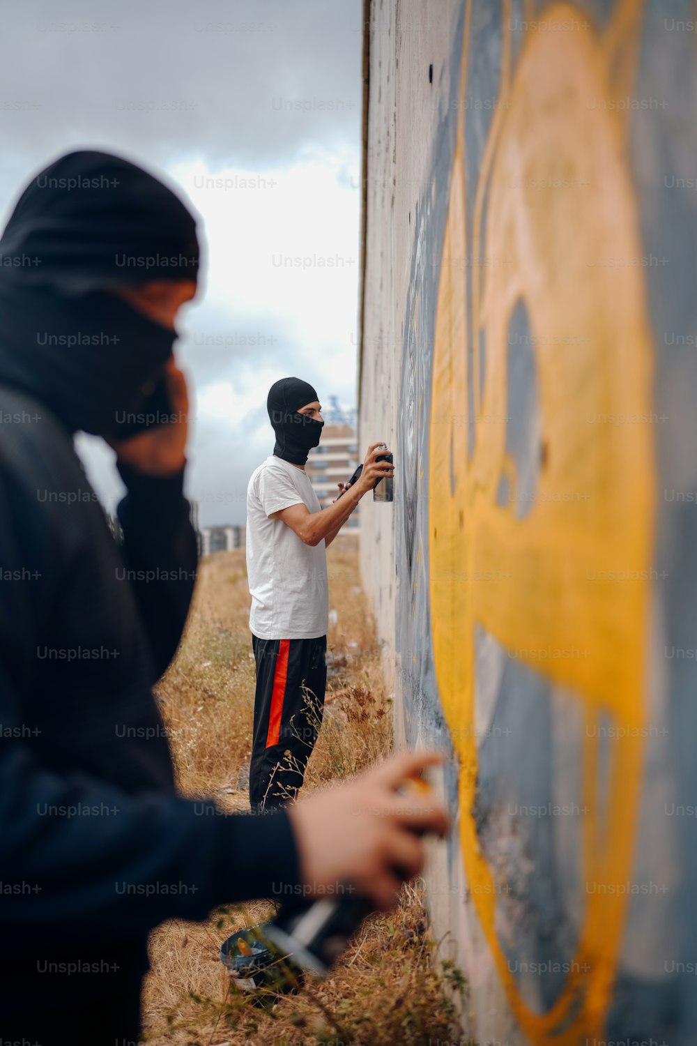 a man painting a wall with a paint roller