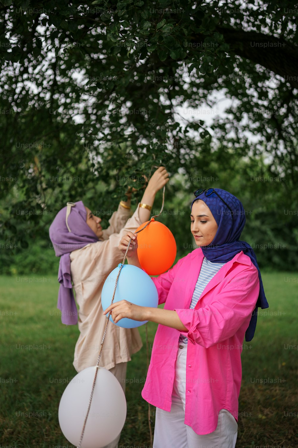 uma mulher segurando um monte de balões em um campo