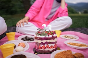 a woman sitting in front of a cake with candles on it