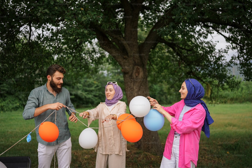 Eine Gruppe von Menschen, die umeinander stehen und Luftballons halten