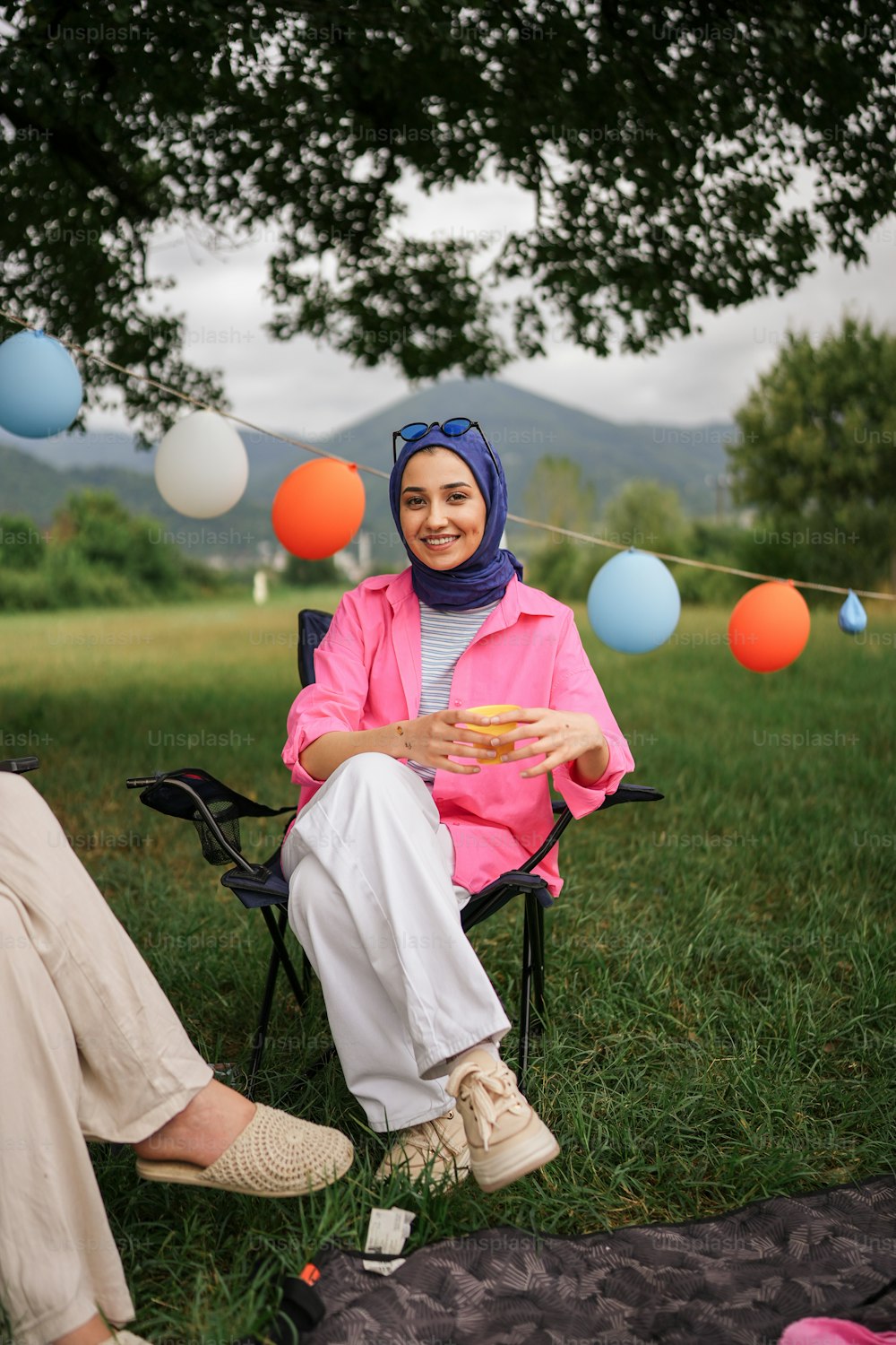 a woman sitting in a chair with a plate of food