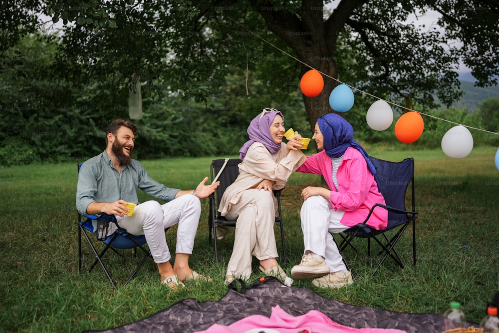 un groupe de personnes assises dans des chaises de jardin sous un arbre