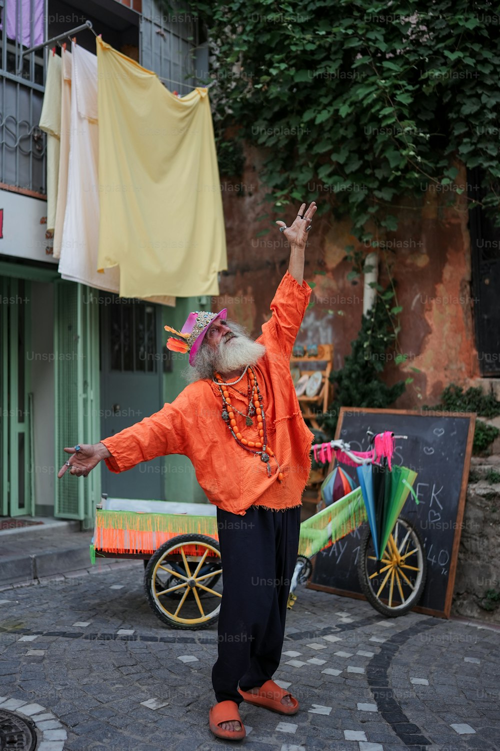 a man in an orange shirt is dancing on the street