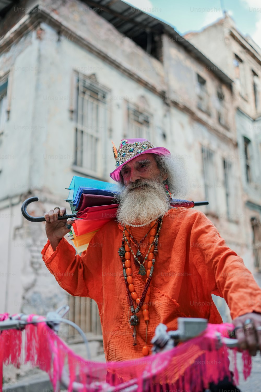 a man with a long white beard and a long beard wearing an orange shirt and