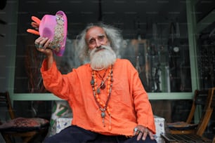 um homem com uma longa barba branca segurando um objeto rosa